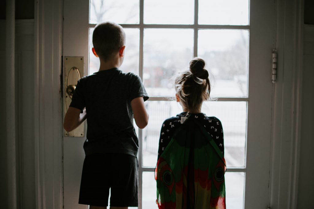 dzieci odwrócone tyłem patrzące przez okno