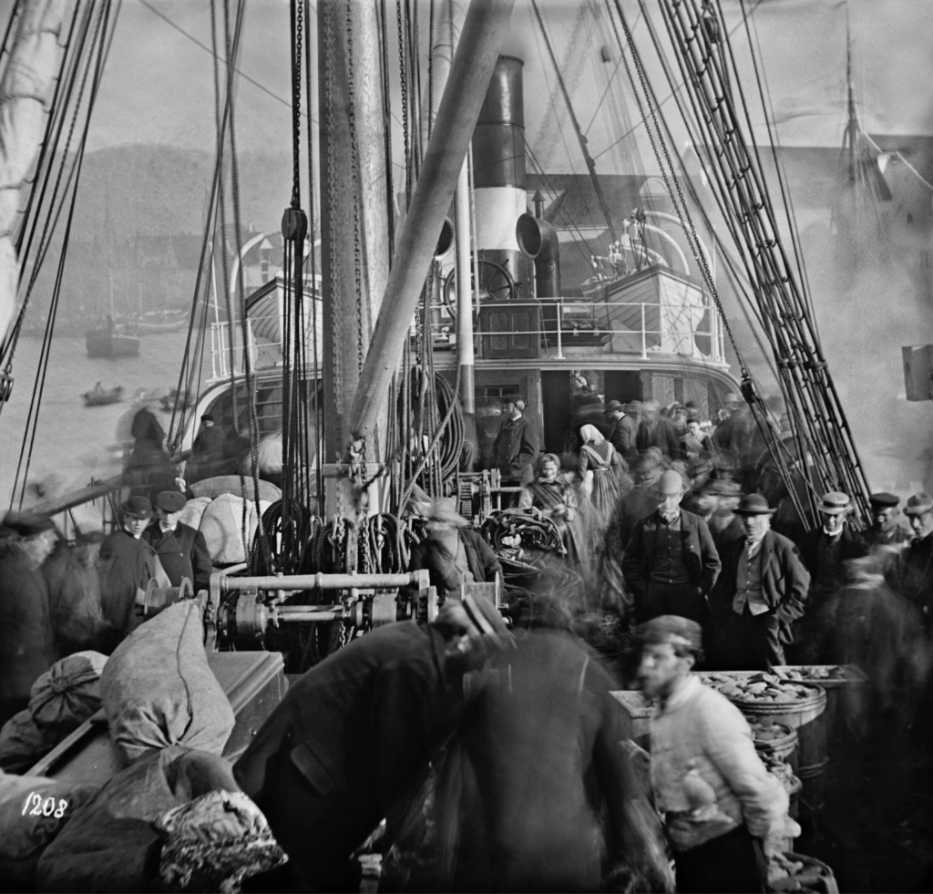 Czarno-białe zdjęcie przedstawiające gotowych do drogi emigrantów z Bergen wybierających się do USA. Foto: Knud Knudsen